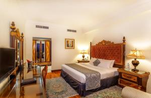 a bedroom with a bed and a flat screen tv at Grand Excelsior Hotel - Bur Dubai in Dubai