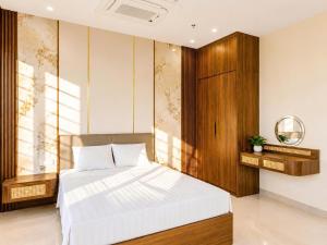 a bedroom with a white bed and a wooden cabinet at O Lily Hotel in Ninh Binh