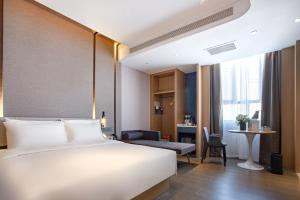 a hotel room with a bed and a desk at 库尔勒孔雀河景观带滨河西路亚朵酒店 in Korla
