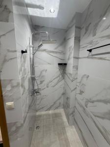 a bathroom with a shower with marble walls at اقامة هبة in Yebha