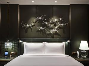 a bedroom with a large white bed and a black wall at J Hotel, Shanghai Tower in Shanghai