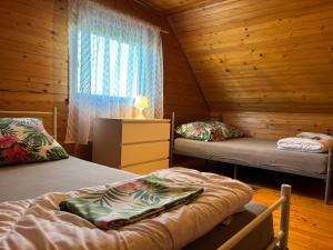 a bedroom with two beds in a wooden cabin at Domki letniskowe Nadia z podgrzewanym basenem in Władysławowo +16 photos