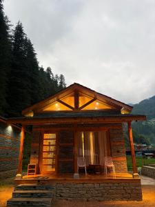 a small cabin with two chairs and a table at The Pravaas Resort in Barot  +22 photos