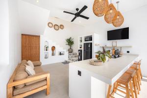 a kitchen and living room with a table and a couch at Anatha Villa Uluwatu in Badung