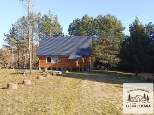 a cabin in the woods with a sign in front of it at Leśna Polana in Zbiczno