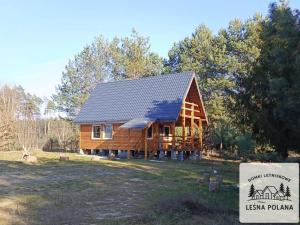 a log cabin with a sign in front of it at Leśna Polana in Zbiczno +4 photos