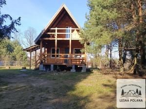 a log cabin with a sign in front of it at Leśna Polana in Zbiczno