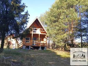 a log cabin with a sign in front of it at Leśna Polana in Zbiczno