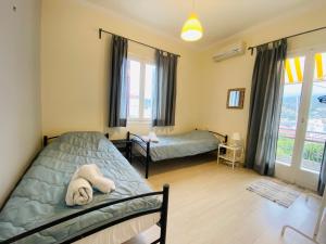 a bedroom with two beds and a window at Island Traditional House in Poros
