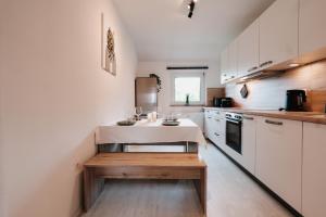 a kitchen with white cabinets and a table in it at Bright Nest in Drensteinfurt