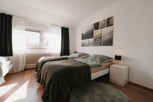 a white bedroom with a bed and a window at Bright Nest in Drensteinfurt