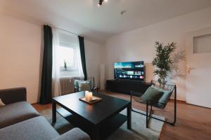 a living room with a couch and a table and a tv at Bright Nest in Drensteinfurt