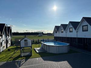 an overhead view of a backyard with a pool and houses at Domki letniskowe Nadia z podgrzewanym basenem in Władysławowo