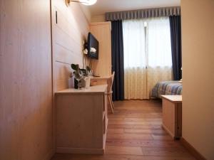 a room with a desk and a bed with a window at Giorgio e Flora Ristorante e Locanda in Arsiero