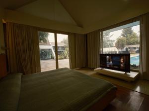 a bedroom with a bed and a flat screen tv at RB Villa in Indore +66 photos