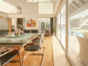 a dining room with a glass table and chairs at RB Villa in Indore