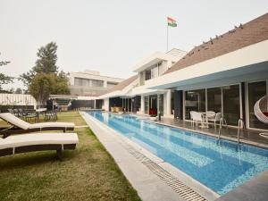 a swimming pool with lounge chairs next to a building at RB Villa in Indore