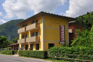 a yellow building with a sign on the side of it at Albergo Silvana in Ledro