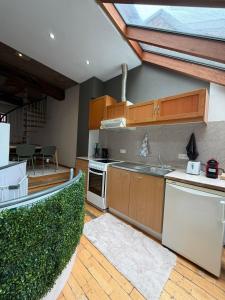 a kitchen with wooden cabinets and a counter top at Le Studio Central in Huy