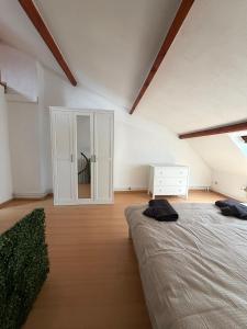 a bedroom with two beds and a dresser and a mirror at Le Studio Central in Huy