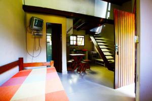 a living room with a tv and a table with chairs at Chales Maresias in Maresias