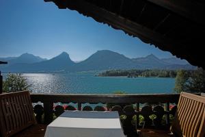 a balcony with a view of a lake and mountains at Strandhotel Margaretha in St. Wolfgang