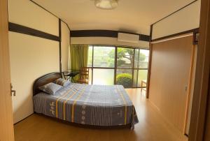 a bedroom with a bed and a large window at 安易旅館3号房间 in Okayama