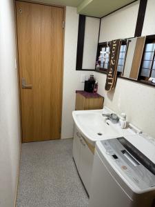 a bathroom with a sink and a washing machine at 安易旅館3号房间 in Okayama
