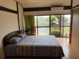 a bedroom with a bed and a large window at 安易旅館3号房间 in Okayama