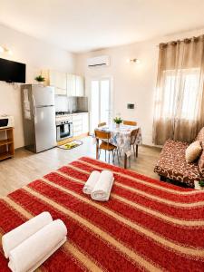 a large living room with a kitchen and a table at Stella Marys Sud in Olbia