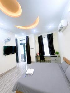 a bedroom with a large white bed and a flat screen tv at 44 đặng dung in Buon Ma Thuot