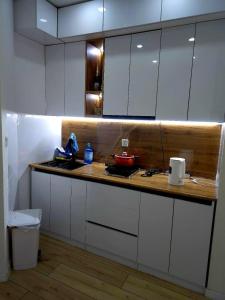 a kitchen with white cabinets and a wooden counter top at Arga bilig complex in Ulaanbaatar +21 photos