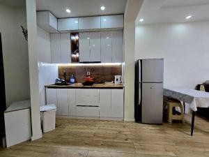 a kitchen with white cabinets and a refrigerator at Arga bilig complex in Ulaanbaatar