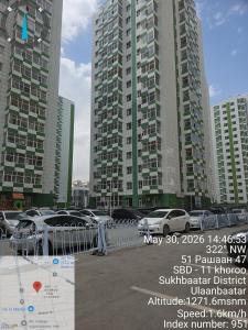 a parking lot with cars parked in front of tall buildings at Arga bilig complex in Ulaanbaatar