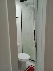 a bathroom with a toilet and a glass shower at Apartamento próximo ao Aeroporto e Curitiba in São José dos Pinhais