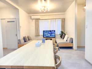 a living room with a table and a couch at seragaki blue twins 201 in Onna