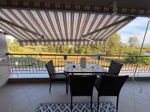 a patio with a table and chairs on a balcony at Apartment Las 2 in Fanari
