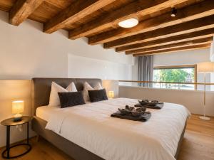 a bedroom with a large bed with shoes on it at LAKE-SIDE Fernblick in Romanshorn +2 photos