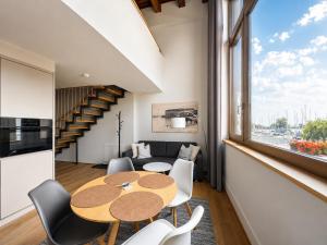 a dining room with a table and chairs and a window at LAKE-SIDE Fernblick in Romanshorn
