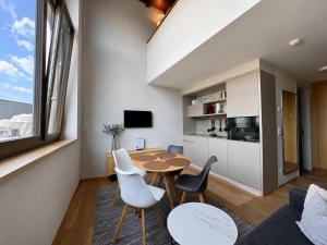 a living room with a table and chairs and a kitchen at LAKE-SIDE Fernblick in Romanshorn
