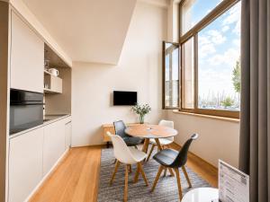 a small kitchen and dining room with a table and chairs at LAKE-SIDE Säntisblick in Romanshorn