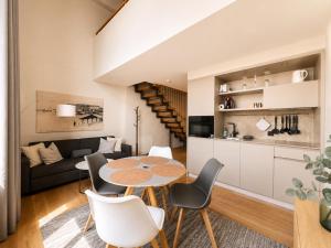 a kitchen and living room with a table and chairs at LAKE-SIDE Säntisblick in Romanshorn +5 photos
