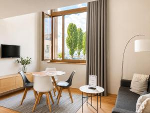 a living room with a table and chairs and a couch at LAKE-SIDE Säntisblick in Romanshorn