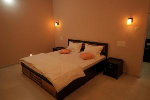 a bedroom with a large bed with two orange pillows at The Calm County Homestay in Mānantoddy