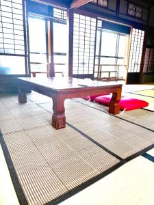 a ping pong table in a room with windows at 安易旅館二楼 in Okayama