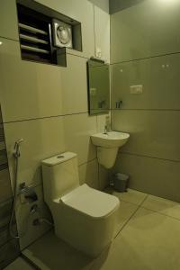 a bathroom with a toilet and a sink at The Calm County Homestay in Mānantoddy