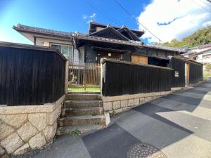a house with a fence and stairs in front of it at 安易旅館二楼 in Okayama
