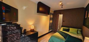 a bedroom with a bed and a flat screen tv at The Hideout Middlesbrough Great Location in Middlesbrough +3 photos