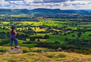 a woman standing on a rock overlooking a green valley at The Hideout Middlesbrough Great Location in Middlesbrough