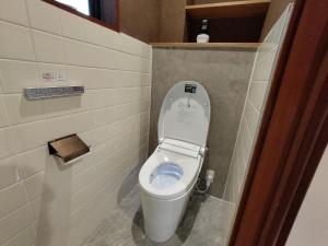 a small bathroom with a toilet with the lid up at 民宿 とうの浜 in Yasuda +5 photos